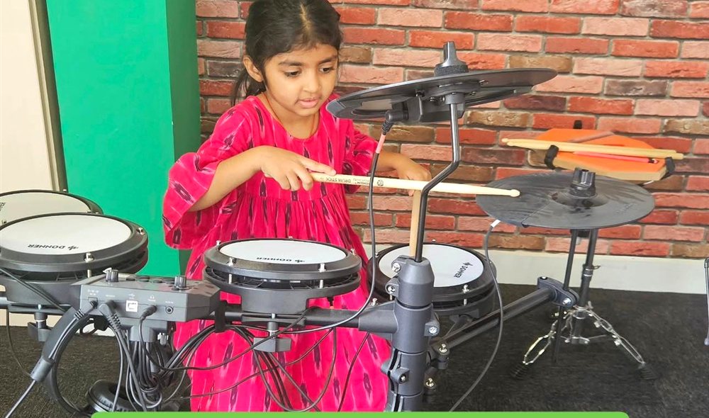 A young student learning drums at Muzeeka Academy, Whitefield